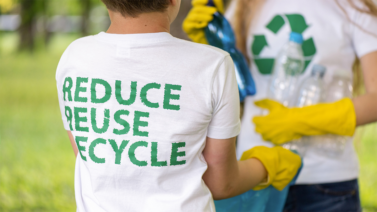 in white shirt with words reduce reuse recycle helping out with waste collection