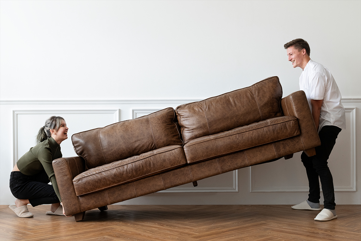 Couple trying to remove bulky waste furniture by themselves instead of a bulky waste removal company